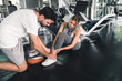 Pretty Woman Having Injury During Exercise in Gym While Her Couple Taking First Aid, Accident and Sport Fitness Concept.