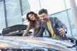 © LIGHTFIELD STUDIOS - selective focus of happy man and girl smiling while looking at car