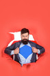 © Svitlana - Through paper. Bearded man looking through paper. Super businessmen in red cape showing blue shirt. Superhero. Symbol s. Business growth. Super power. Business. Copy space. Sale. Discount.