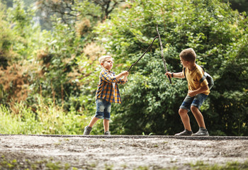 Wall Mural - two boys playing fight with wooden swords.childhood concept.