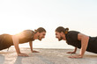© Drobot Dean - Two twin brothers doing exercises at the beach together