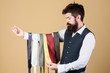 © be free - Tie the perfect for daily wear. Bearded man choosing neck tie. Brutal hipster holding colorful tie collection. Offering a huge selection of ties