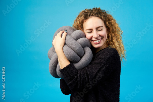 Fotomural Young attractive smiling cheerful curly ginger girl hugs a soft toy with pleasure