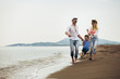 © Mediteraneo - Mother and father with their son walking together on a quiet beach.