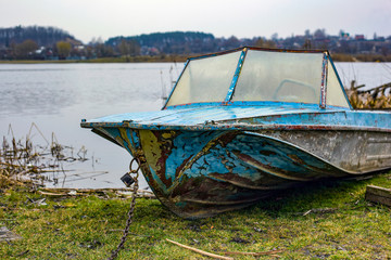 old blue boat moored on shore