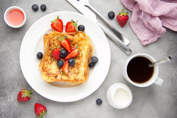 Canvas Print - French toast with berries (blueberries, strawberries) and sauce, traditional sweet dessert of bread with egg and milk. Morning baking food