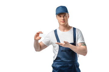 Wall Mural - handsome mover in uniform holding blank business card and gesturing with hand isolated on white