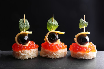 Tasty canapes on dark background