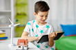 © Syda Productions - ecology, technology and energy saving concept - smiling boy with tablet pc computer, toy house model and wind turbine at home