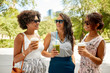 © Syda Productions - leisure, people and friendship concept - happy women or friends with takeaway drinks talking summer park