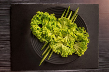 Green salad, lettuce, microgran, cucumber, pepper on a black plate. Healthy Eating