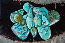 Pile Of Polished Turquoise Stones On Black Surface