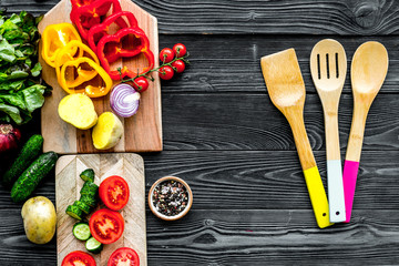 Fresh organic vegetables for healthy food cooking on black wooden background top view