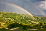Fototapeta Tęcza - Beautiful mountain valley with green hills and huge rainbow