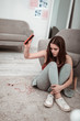 © Viacheslav Yakobchuk - Sad teenager girl crashing her smartphone on the floor