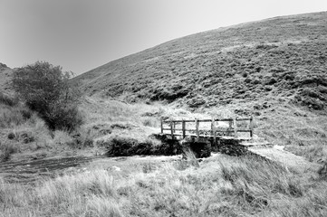 Isolated wooden footbridge over a river on Exmoor, Somerset, UK