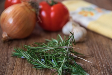 Wall Mural - Fresh rosemary, tomato, garlic and onion on wooden table 