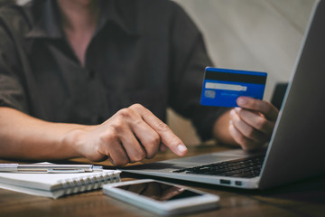 Businessman holding credit card and typing on laptop for online shopping