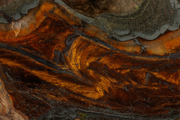 Wall Mural - Macro stone tiger eye mineral in rock on black background