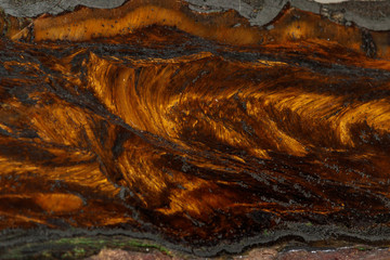 Macro stone tiger eye mineral in rock on black background