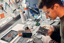 The Technician Carefully Examines The Integrity Of The Internal Elements Of The Smartphone In A Modern Repair Shop