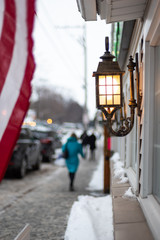 people walking along sidewalk outside stores in small town america