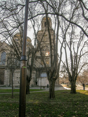 Wall Mural - View of the stone Church behind the trees with stained glass Windows