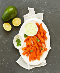 Canvas Print - Baked spiced pumpkin slices with avocado sauce. shooting from above.