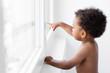 © Lisa Tichané - Baby boy looking out by the window pointing