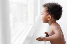 Black Baby Boy Looking Out By The Window