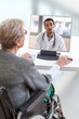 © JPC-PROD - disabled Senior woman consults a e-health doctor with tablet computer sitting on wheelchair . In touchscreen, male doctor: