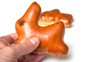 closeup of  traditional  buns in shaped rabbit with dried raisin in hand on white background