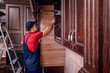 © Ахтем - A young worker is assembling modern wooden kitchen furniture.
