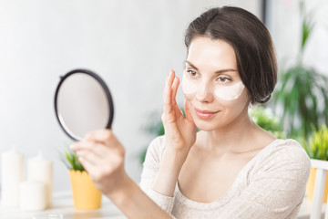 Makeup remove skin care. Closeup woman holding cotton swab and makeup remover liquid cosmetic in hands. Woman cleaning her face with lotion and cotton pad