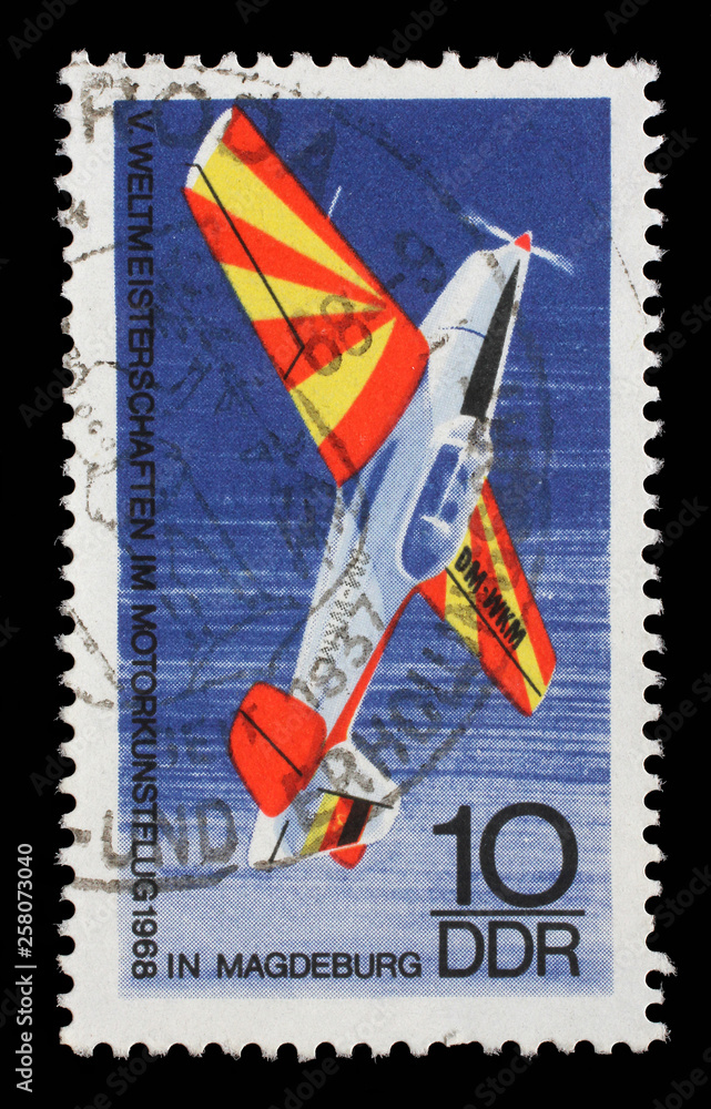 Stamp issued in Germany - Democratic Republic (DDR) shows Sports airplane "Trener", World Championship of Aerobatics in Magdeburg, circa 1968. - obrazy, fototapety, plakaty 