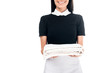 © LIGHTFIELD STUDIOS - Cropped view of smiling maid in uniform holding towels isolated on white