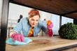 © zinkevych - Cheerful hard-working lady applying cleaning spray on wooden shelves
