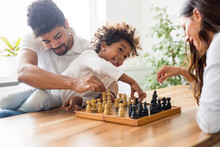 Happy Family Playing Chess Together At Home