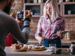 © golubovy - Food blogging business. Couple lifestyle. Man shooting woman pointing at muffin. Pastries assortment around.