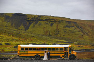 Wall Mural - Beautiful wedding couple posing with yellow school bus