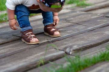 The boy is walking on the grass