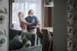 © Yakobchuk Olena - Positive elder couple dancing in living room