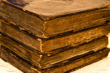 Canvas Print - Stack of old and worn leather cover books with gold leaf embossing