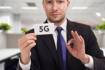 Business, technology, internet and networking concept. Young entrepreneur showing keyword: 5G