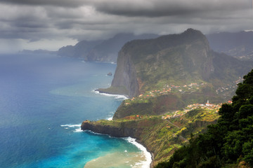 Wall Mural - Beautiful view of the coastline of the island Madeira with vibrant green nature and blue ocean during a levada hike