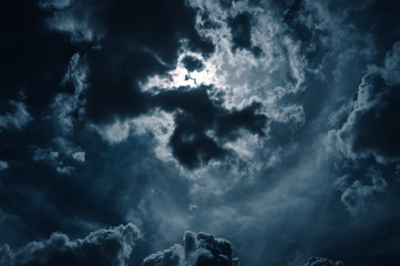 Wall Mural - moonlight shines behind a cloudy at night. serenity nature background.
