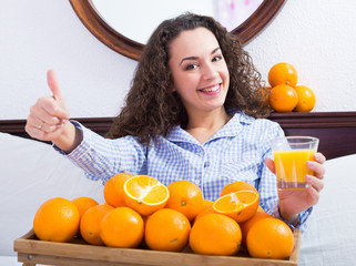 Wall Mural - Positive girl with ripe oranges and glass of juice