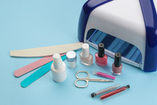 Manicure. Nail Polishes, UV Lamp And Various Accessories And Tools For Manicure On A Trendy Blue Background.