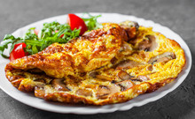 Omelette With Mushrooms And Arugula Salad In White Plate On Dark Grey Black Slate Background