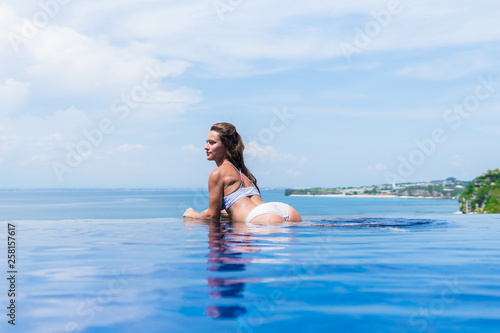 sexy girl. beautiful woman. model lady bikini underwear big ass butt booty  sit edge of water swim pool on the roof of luxury resort hotel nice sea  scenery long shot - Buy
